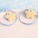 Silver hoop earrings with yellow clay flower