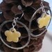 Silver hoop earrings with yellow clay flower