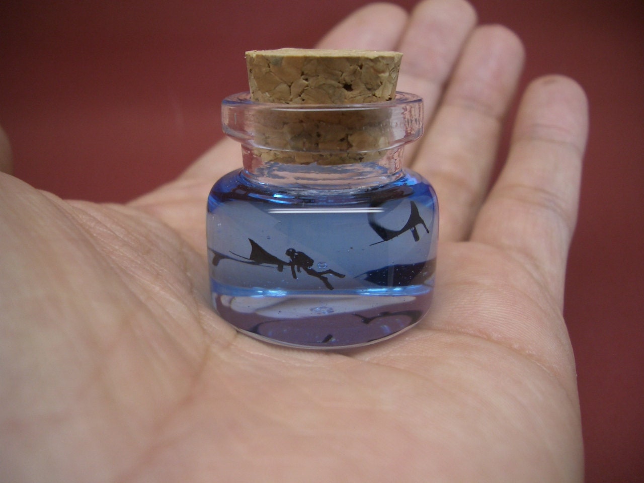 Mantas and a diver are in a tiny bottle