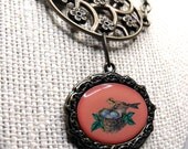 Garden Party Necklace--Bird's Nest Pendant, Antiqued Brass, Green Glass Leaves, Coral Beads