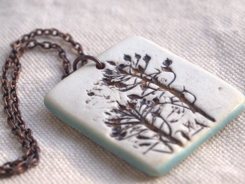 Understanding - An earthy porcelain pendant with impression of Sweet Alyssum.