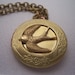 The  Hunger Games real not real hand stamped Peeta's  locket with mockingjay