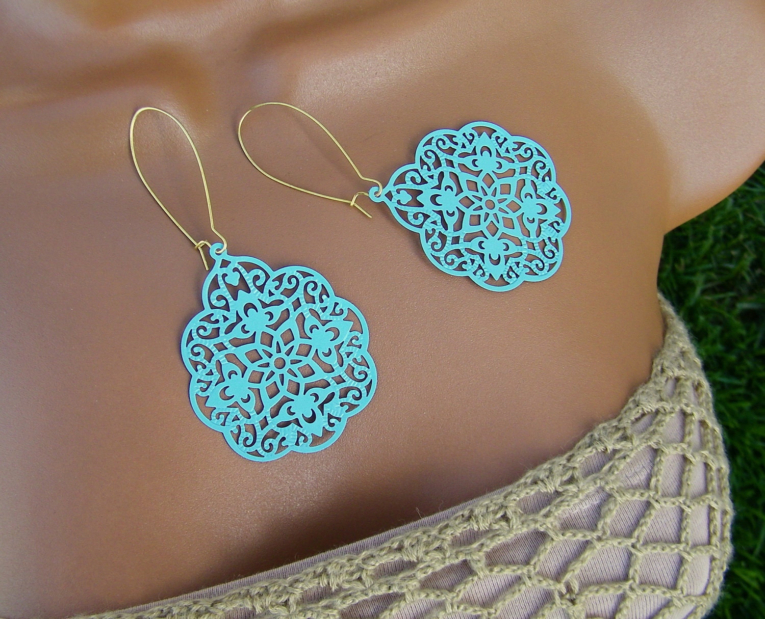 Pretty aqua mint blue lacy filigree earrings. 1 7/8" wide and 3" long. The photo shows the earrings with gold plated earwires. This listing also allows you to select silver plate if you prefer. The dangles are enameled in this pretty cool, mint blue. Bold, feminine statement.