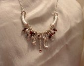 Fanciful Sterling silver necklace chockfull with charms of red crystals, pearls, and hearts
