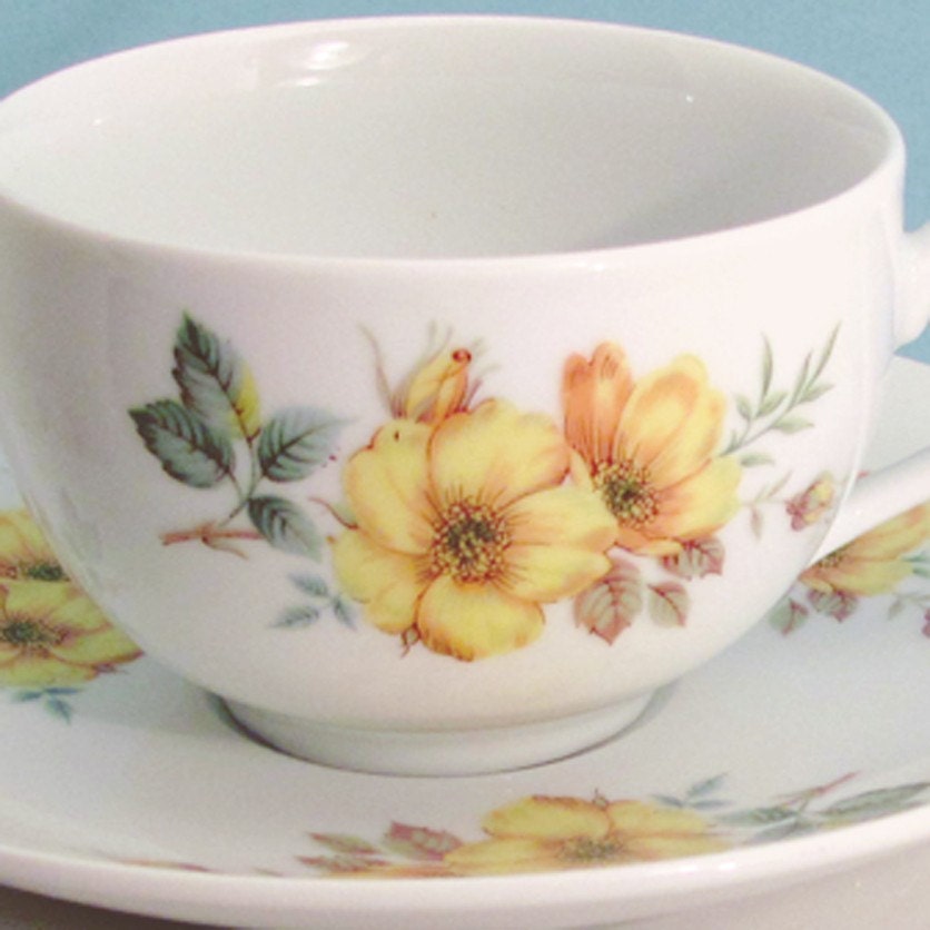 Vintage style cup and saucer with yellow roses with brown and green leaves
