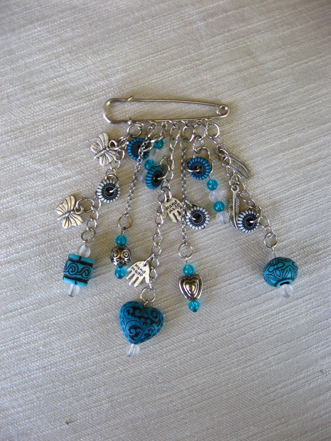 silvertone  brooch ,kilt pin -  turqize with black beads with silvertone charms
