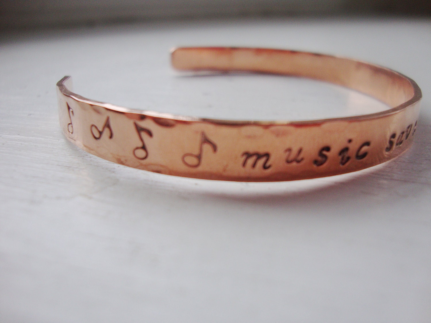 Music saves lives handstamped copper cuff bracelet with music notes.