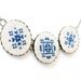 Cross stitch necklace with three navy blue ornament in bronze