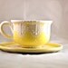 Tea cup and saucer hand painted in yellow shabby chic style