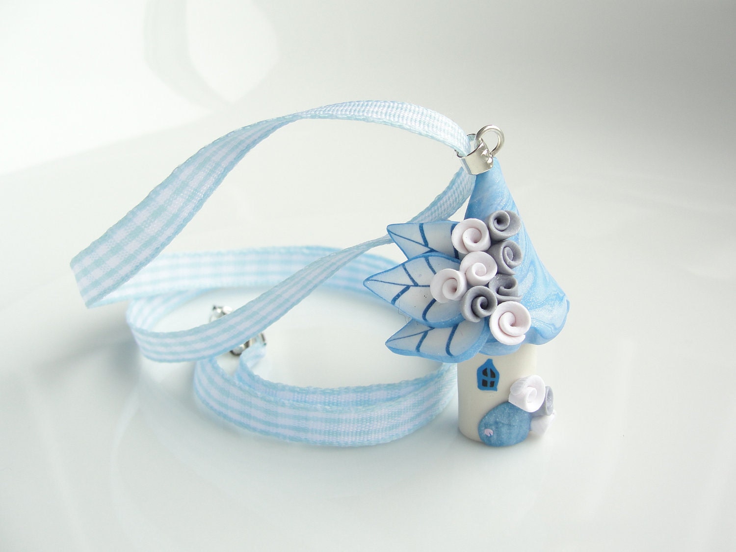 Fairy house childrens necklace in pale blue colours handmade from polymer clay on blue gingham ribbon