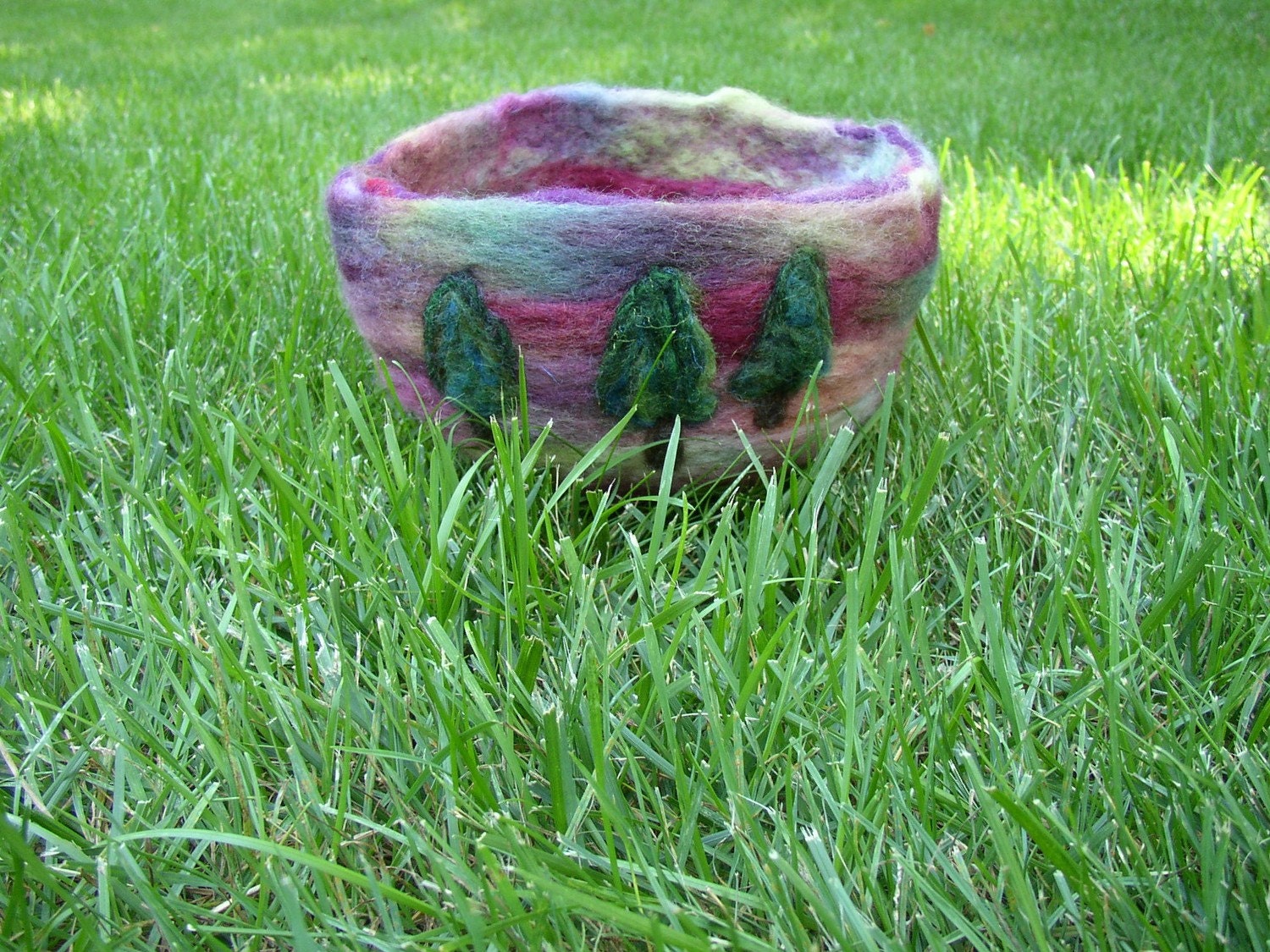deep green fir tree cluster surrounded by burgundy, purple and pink, a wool needle felted bowl