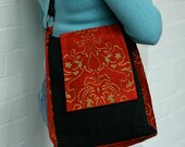 A black velvet handbag with red and gold brocade sides and front flap