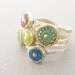 Circles ring in Sterling silver, five bands with circles are in shades of blue, green, turquoise and purple