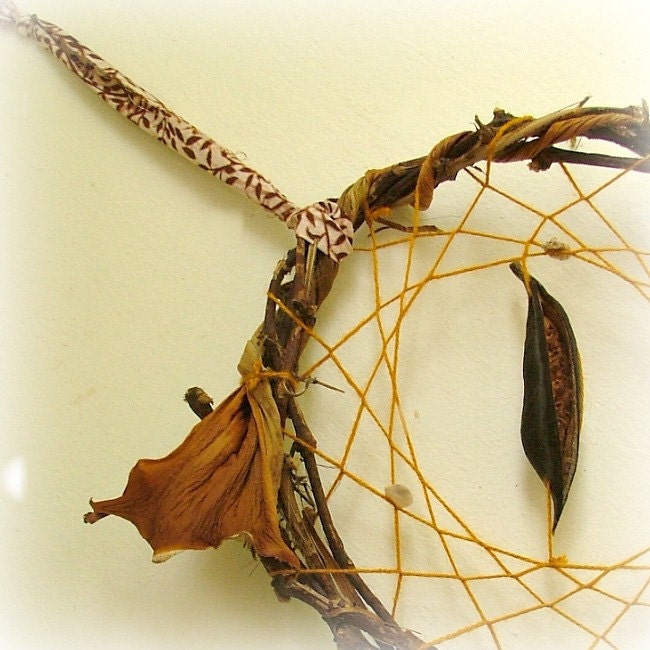 Gorgeous baby crib mobile - dream catcher weaved in mustard yarn and adorned with natural pods, seeds and a feather.