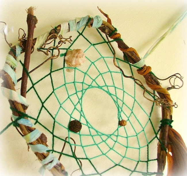 Baby mobile earth art magical dream catcher weaved in 2 shades of green with black pods and spotted feathers.