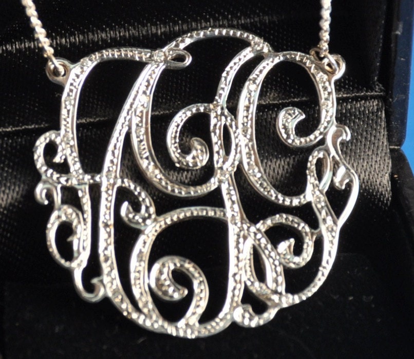 1 1/4" sterling silver monogram, 30 cubic zirconia stones pave' set in monogram to look like diamonds