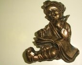Brooch of a child reading a book