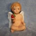 Handpainted Ceramic Cherub with sparkling wings and holding a strawberry