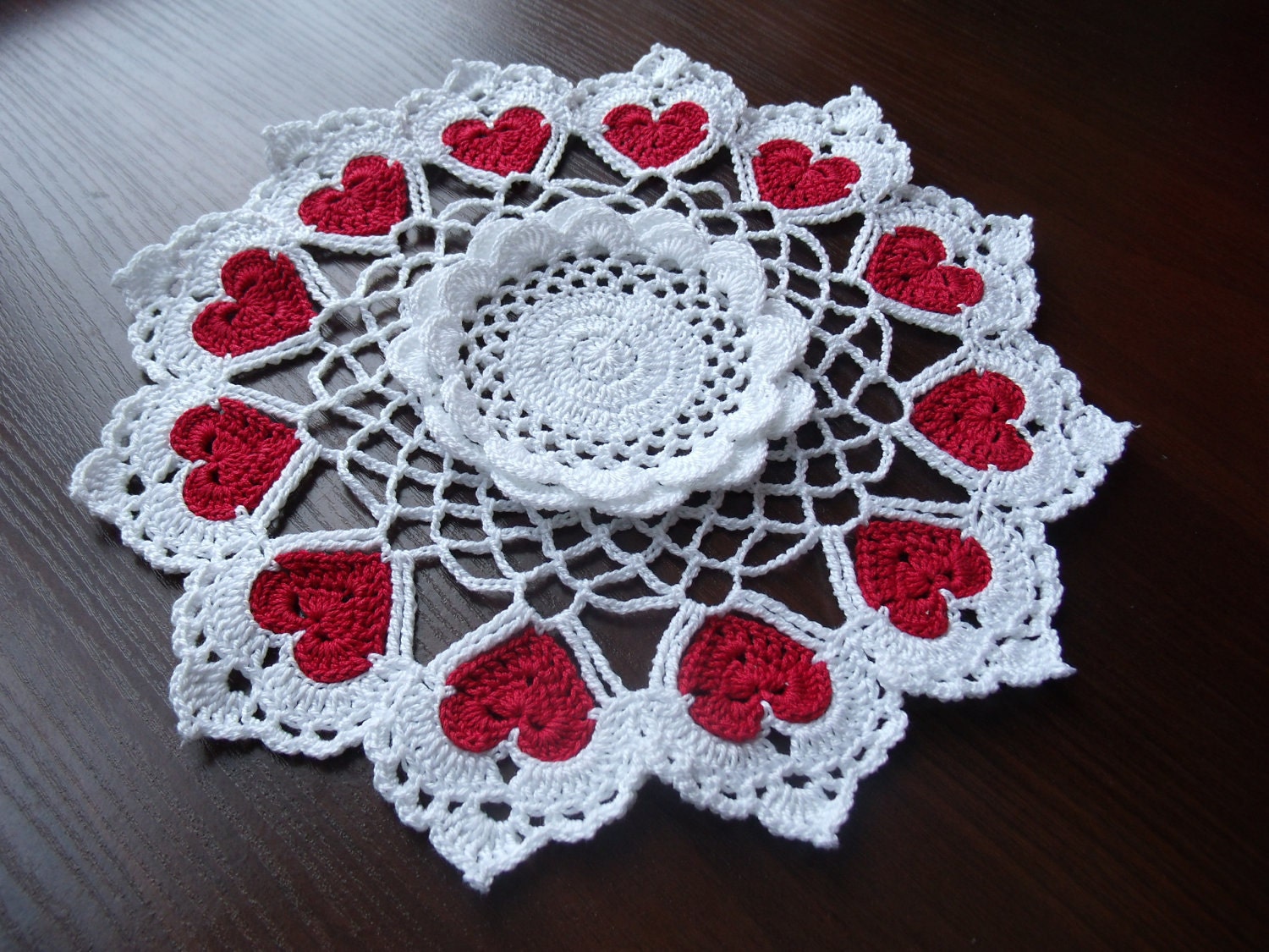 Hand crochet white doily with 12 red hearts