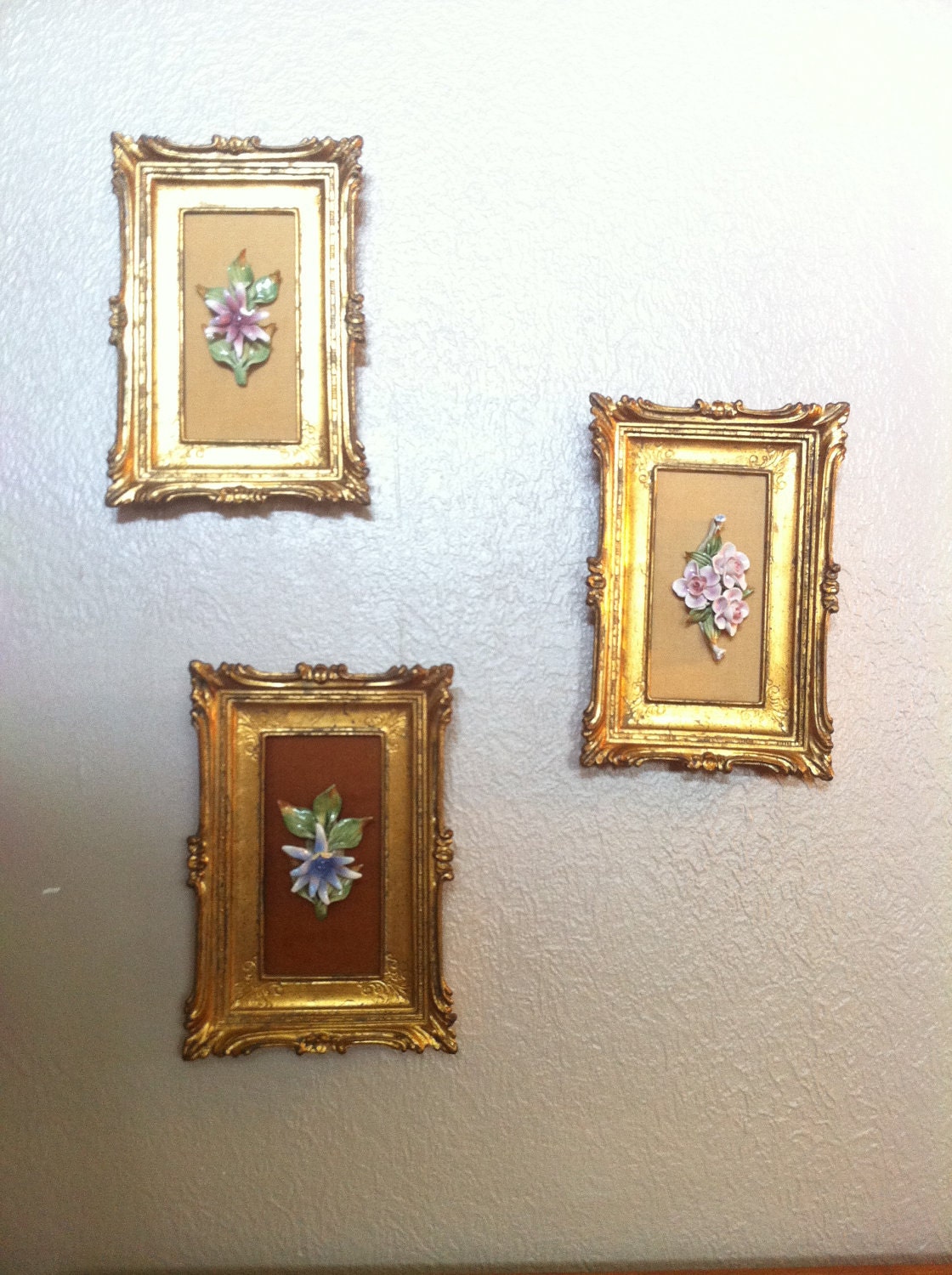 Set of three ornate gold frame wall hangings with ceramic flower art on velvet backing SALE