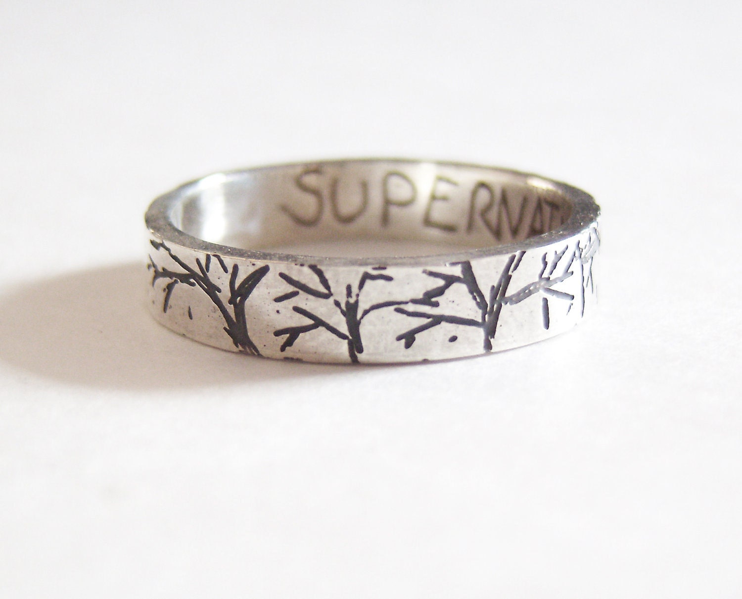 Supernatural creepy forest etched silver ring with SUPERNATURAL etched inside.