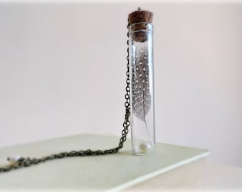 Guinea-Feather curiosity bottle necklace- Polka dot feather Specimen,glass vial, freshwater pearl,brass chain.