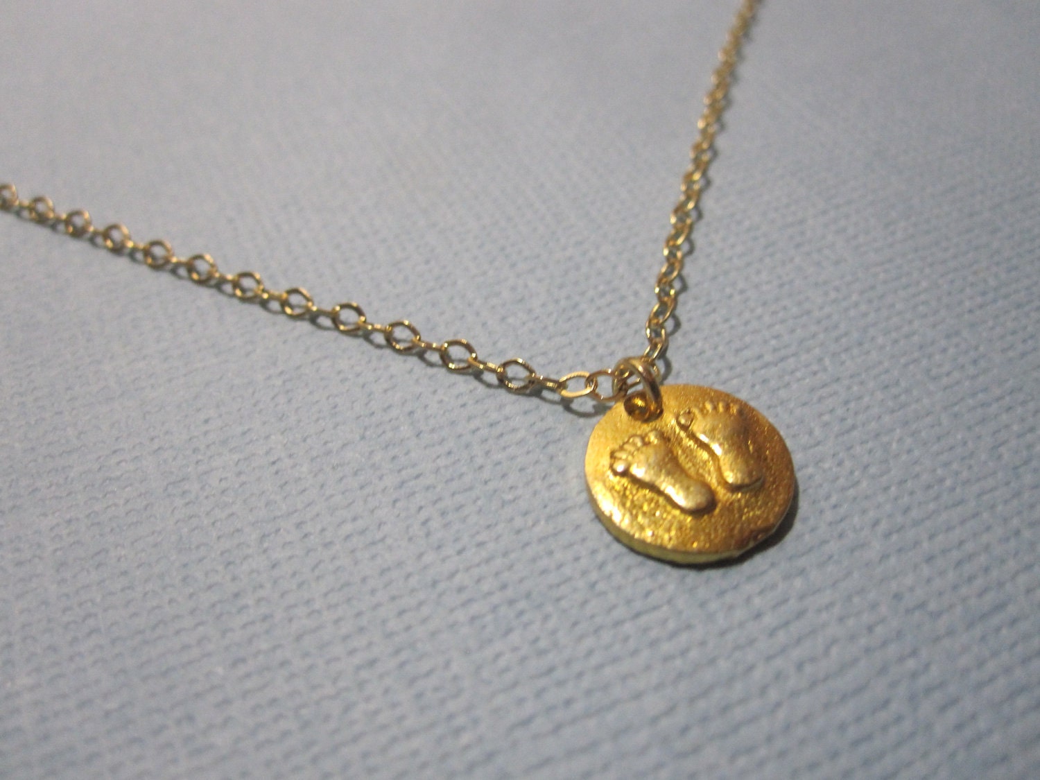 Tiny Baby Feet Necklace available in gold or silver