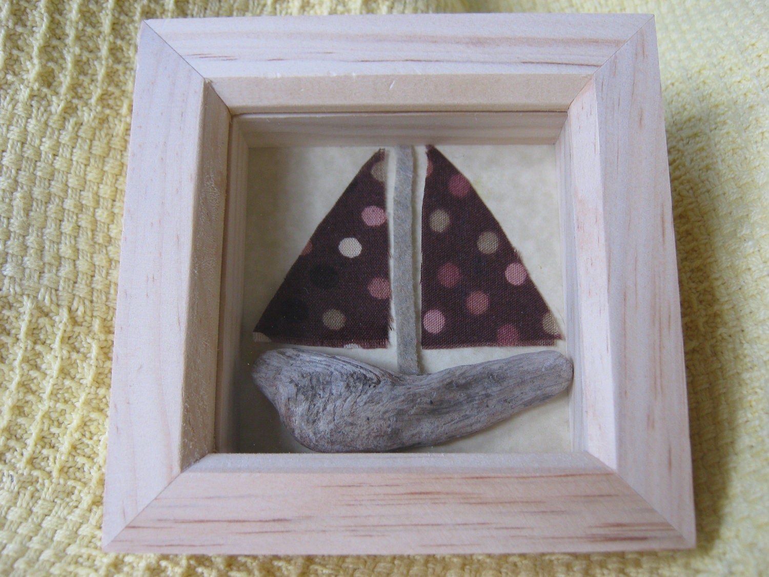 A picture of a handmade driftwood and vintage fabric boat.