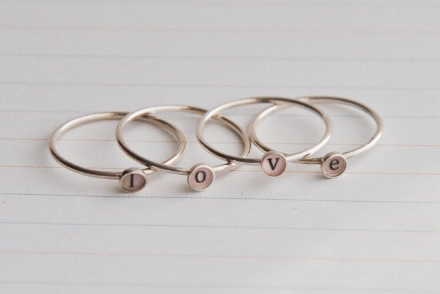 Set of four lowercase initial rings , sterling silver