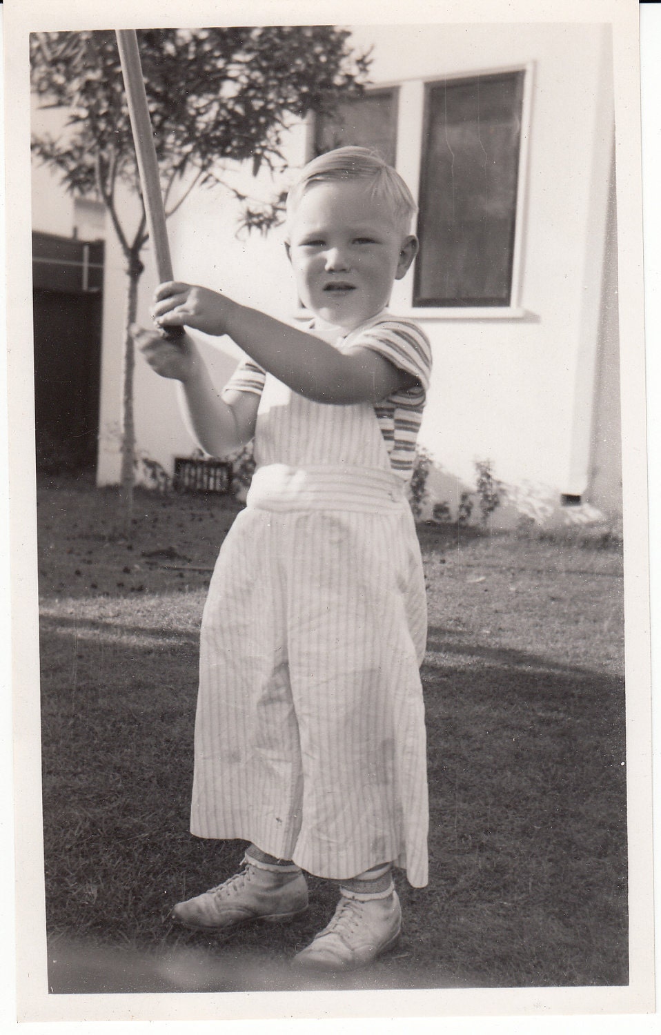 Vintage/Antique photo of a cute little boy in stripe shirt and jumper