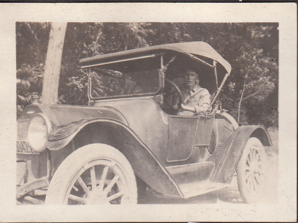 Vintage/ Antique photo of a man driving a vintage car
