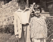 Vintage/ Antique Photo of a boy in an oversized outfit and a cute girl with an oversized bow and stripe jacket