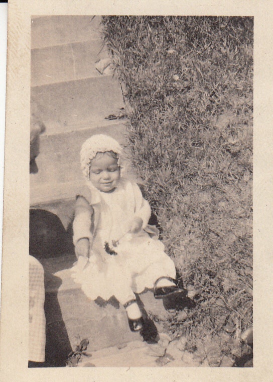 Vintage/ Antique photo of a cute baby in a dress and bonnet