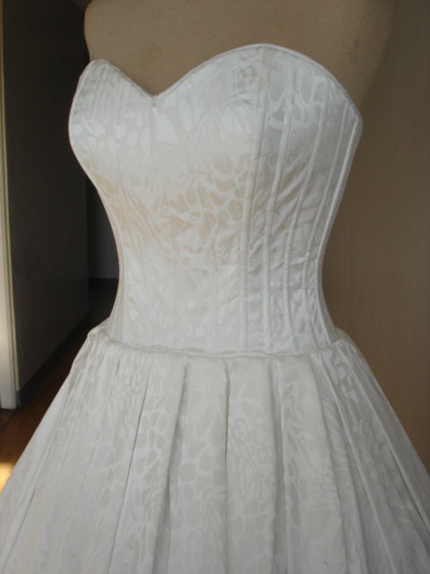 A beautiful white 50s style brocade cocktail dress with laced back and pleated skirt. Design can be made to measure. All sizes welcome.