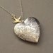 Silver heart locket necklace with gold flying bird