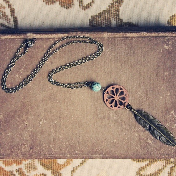 thea. a wood and brass feather necklace.