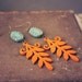penelope. a pair of orange and teal boho leaf earrings.
