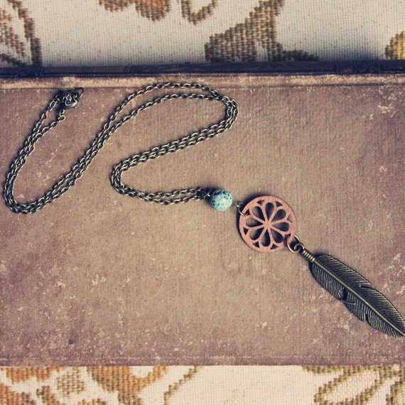 thea. a wood and brass feather necklace.