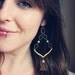 maya. a pair of green and gold mixed metal geometric earrings.