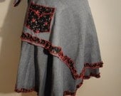 assymetrical length, designed wrap skirt. light denim fabric with designed floral pocket.