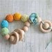 Teething toy rattle with crochet wooden beads and 3 wooden rings. Yellow, orange, light green, aqua blue/ cyan.
