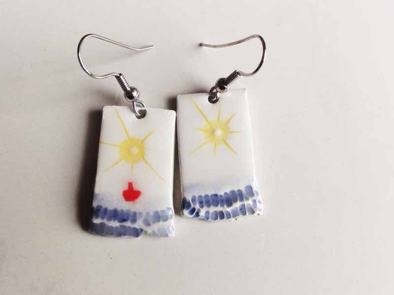 White ceramic dangle earrings with sun, sea and a little red boat