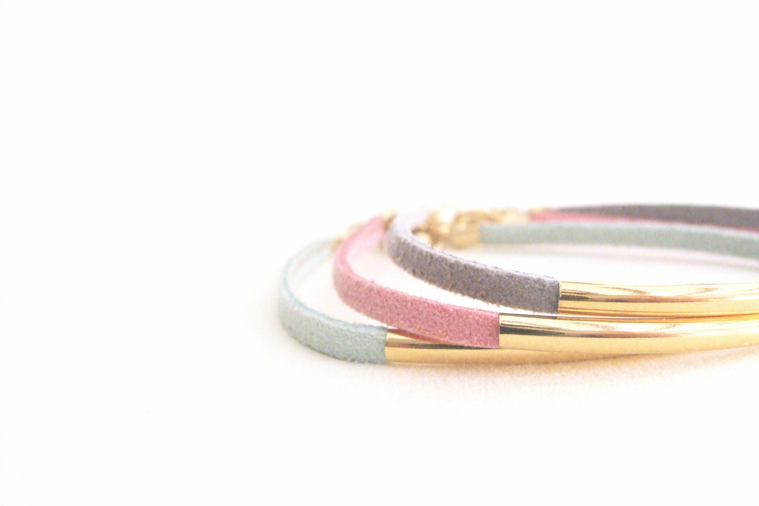 Trio suede leather bracelets in pastel colours with golden arc tube. Pink mint and grey lovely combination