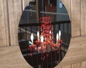 Crimson Perch-----An Illustration of a teal bird perched upon a red crystal chandelier Infused onto a 14" High Gloss Metal Oval
