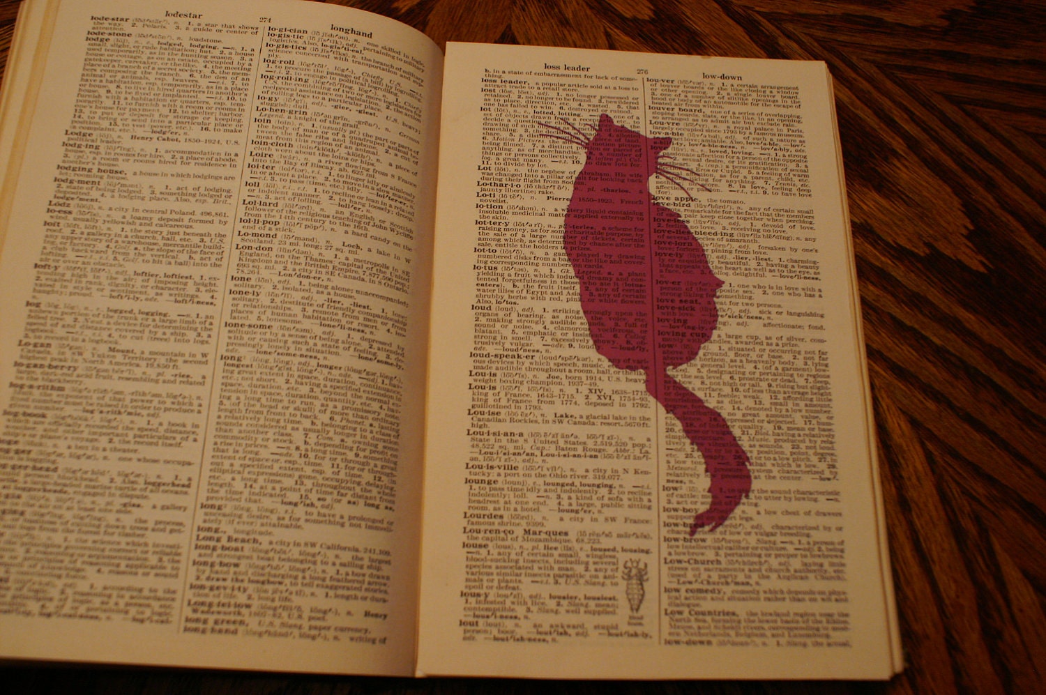 Magenta cat sillouette on vintage dictonary page