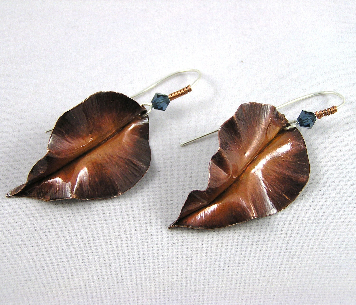 Fold formed copper and sterling silver leaf earrings with teal Swarovski crystals