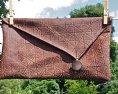 patterned leather asymetrical clutch with adorable feather-print lining