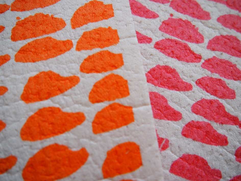 A pair of hand printed "Hundreds & Thousands" dishcloths in orange and pink - biodegradable