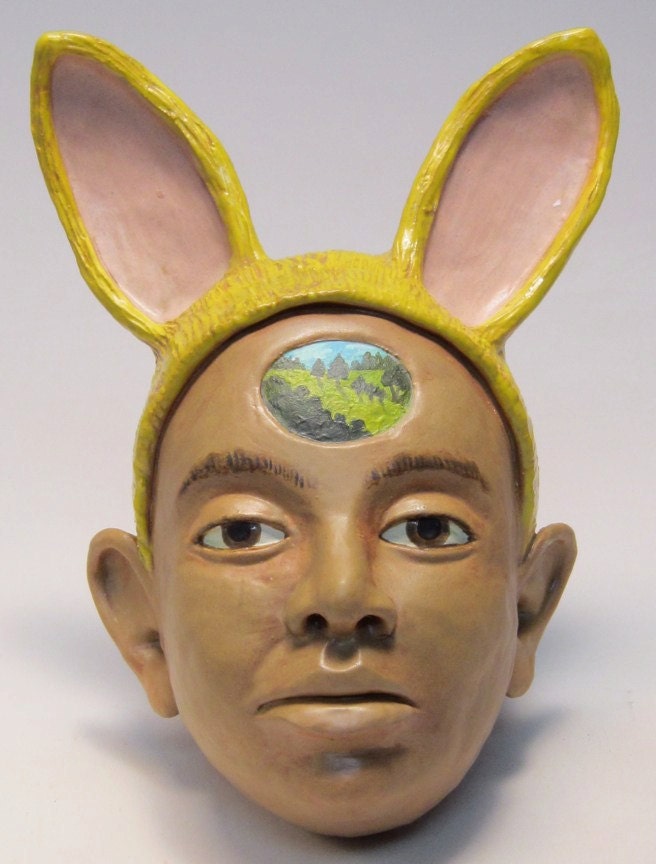 Woman with yellow rabbit ear headress - hand built low fire ceramic figurative wall face sculpture by Carrianne Hendrickson