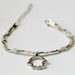 Braided Hamsa Bracelet- braided bracelet with a silver plated hamsa charm and 3 cords: gray, blue, beige. Decorated with silver plated beads